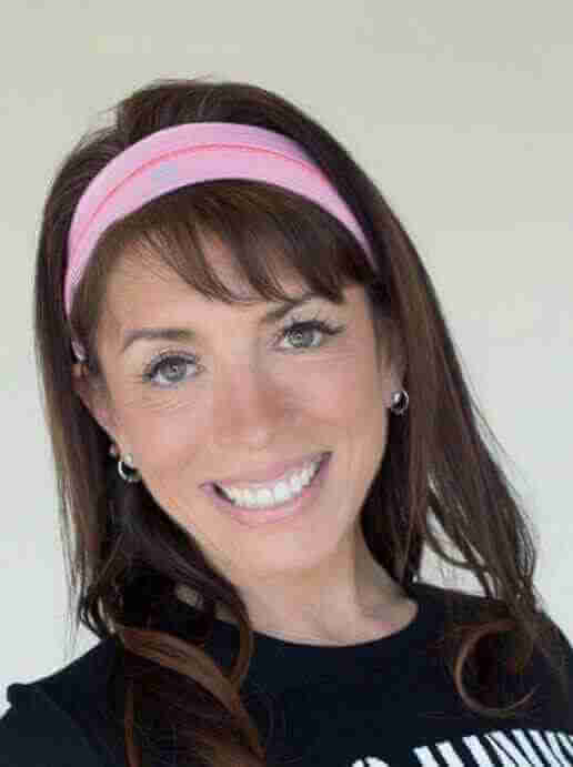 Michelle Burks - Yoga Teacher Asana at Home. close up photo. brown hair and pink headband. smilling