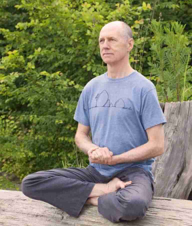 Bernie Clark a man. sitting crossed legged hands clasped at front mediating in the forest. for online meditation course. yoga blog vedic meditation training YACEP