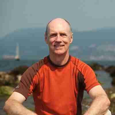 Bernie Clark Yoga Teacher sitting on a beach