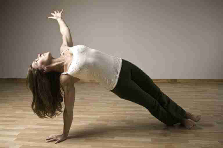 Nathalie Keiller doing a side Plank in a yoga studio asana at home. Picture taken for the Yoga Schedule