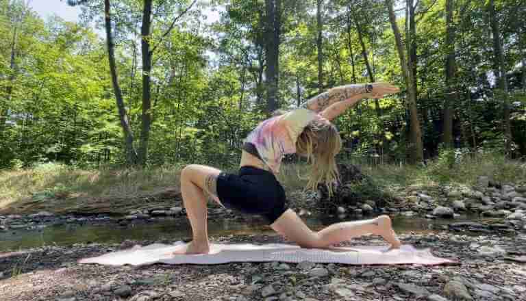 Melissa Berry Yoga Teacher doing a low lunge in the forest