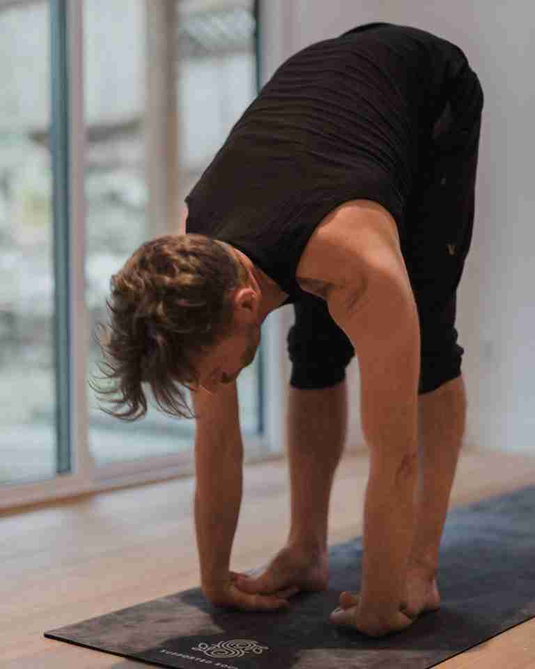 man treating blocked third eye chakra symptoms with a standing forward fold. Kevin Parenteau Ashtanga Yoga Teacher