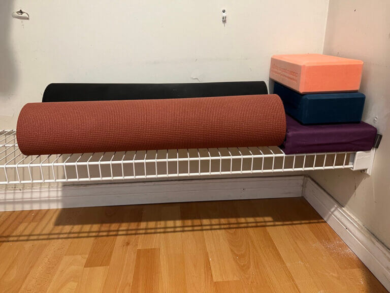 two yoga mats and yoga blocks placed on white wire towel holders for a diy yoga mat storage