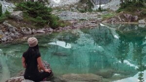 woman mediating with a mountain in the background. root grounding meditation. unblock chakra