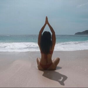 womam sitting on a beach. sitting on the sand. ocean waves. root grounding script
