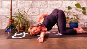woman doing Thread the Needle (Parsva Balasana) yoga pose for shoulder pain