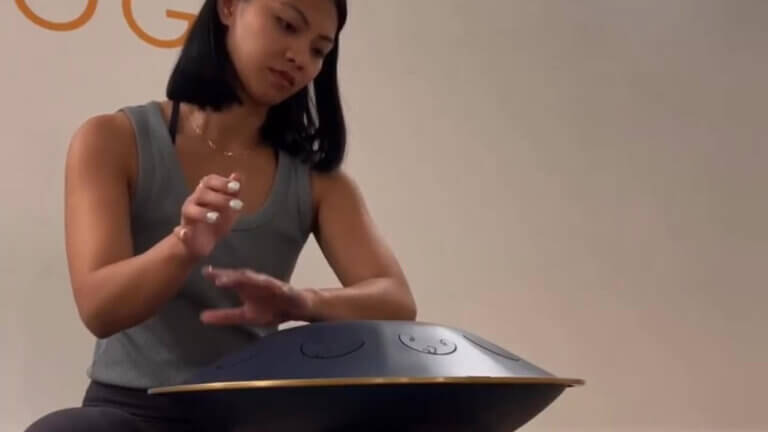 woman playing handpan drum for sound meditation
