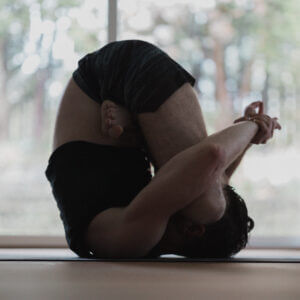 man performing yoga pose Fetal Position (Pindasana) for yoga sleep position