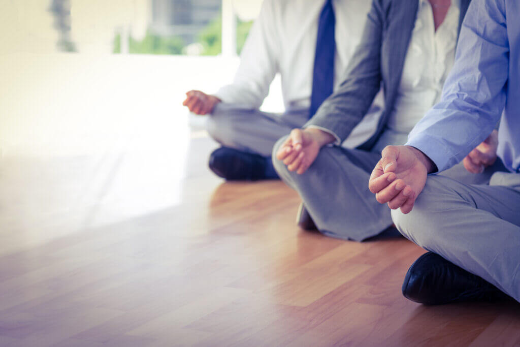 Close up view of business people doing yoga and meditationclasses in office