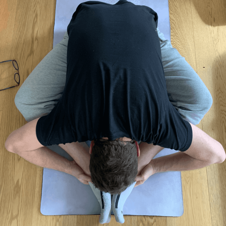 man doing a butterfly yoga pose forward fold Baddha Konasana or Bound Angle Pose