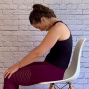 woman doing cat yoga pose at her desk