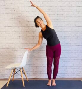 woman standing doing crescent moon pose at office for printable sequence