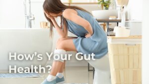woman sitting on toilet holding her stomach. constipated. needs exercise to clean