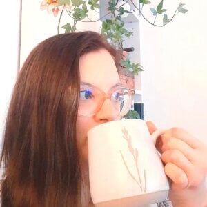 close up of Doro Baumfalk online yoga teacher trainer. teaches journaling for yoga classes, themes, retreats, workshops. she's drinking a coffee