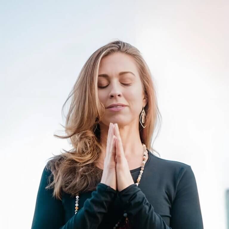 image of a woman. upper body hands in prayer position. woman is christina raskin ERYT 500 trainer for 200 RYT. helping people to learn about yoga