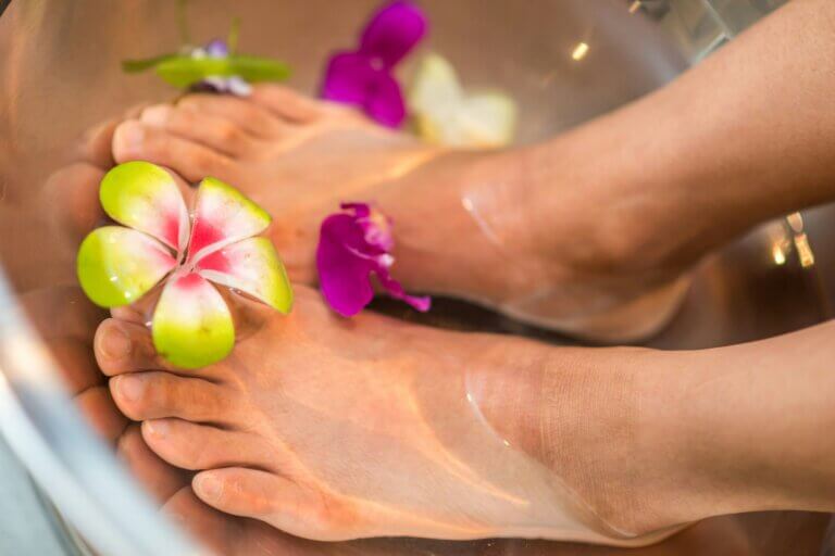 woman's feet bathing in root chakra essential oils