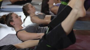 Christina raskin doing a pilates core exercise in a class. Pilates can be blended with Yoga