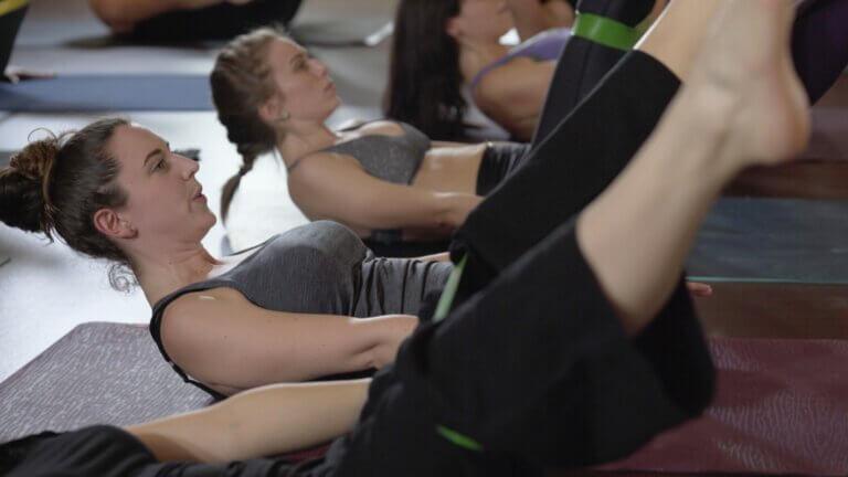 Christina raskin doing a pilates core exercise in a class