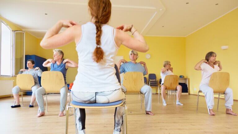 Office workers practicing chair yoga for stress relief.