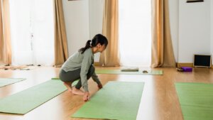 Yoga teacher pausing in a studio space, representing self-discovery and authentic teaching