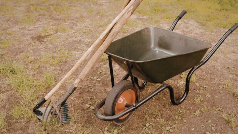 Shovels and wheelbarrow on soil, April yoga newsletter hero image