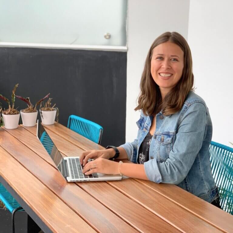 amanda kingsmith sitting at a table hands on laptop computer