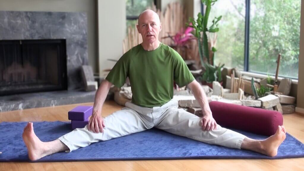bernie Clark seated in Dragonfly Straddle pose yin yoga