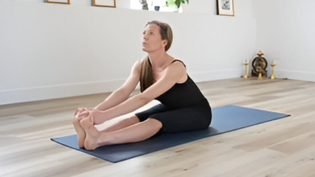 Fiona Stang seated in yoga practice in a bright studio