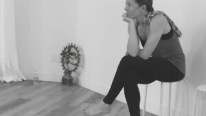 Fiona Stang sitting quietly in reflection beside a yoga altar