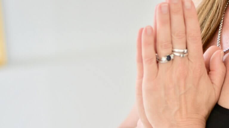 Close-up of Fiona Stang’s hands in prayer during yoga practice