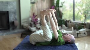 Bernie Clark doing a happy baby pose (Ananda Balasana) in yin yoga