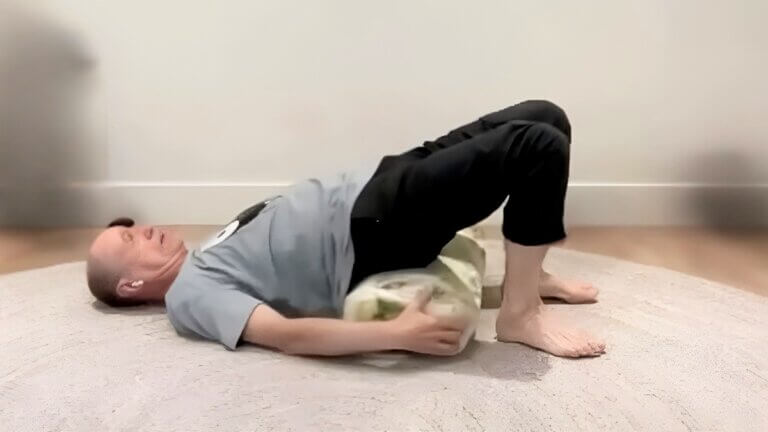 Bernie Clark demonstrating a supported bridge yin yoga pose