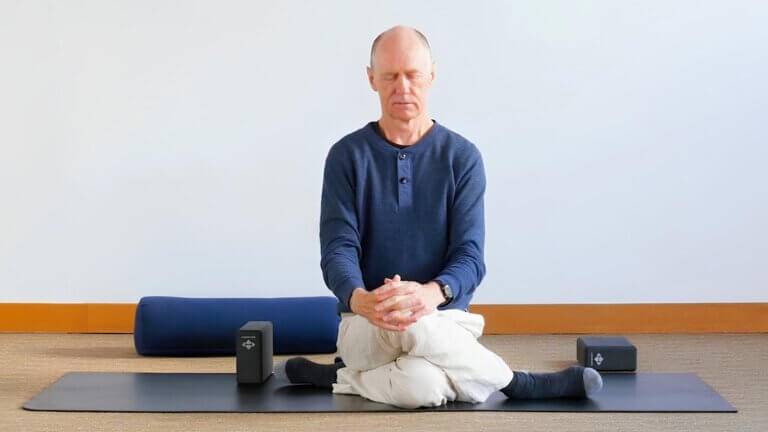 Bernie Clark sitting in a shoelace yin yoga pose
