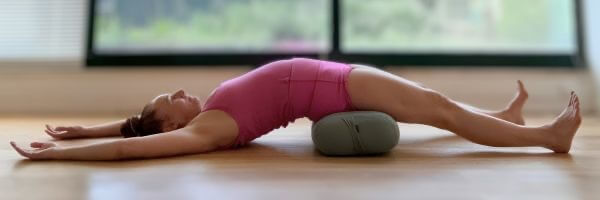 woman doing a supported bridge pose for yoga newsletter