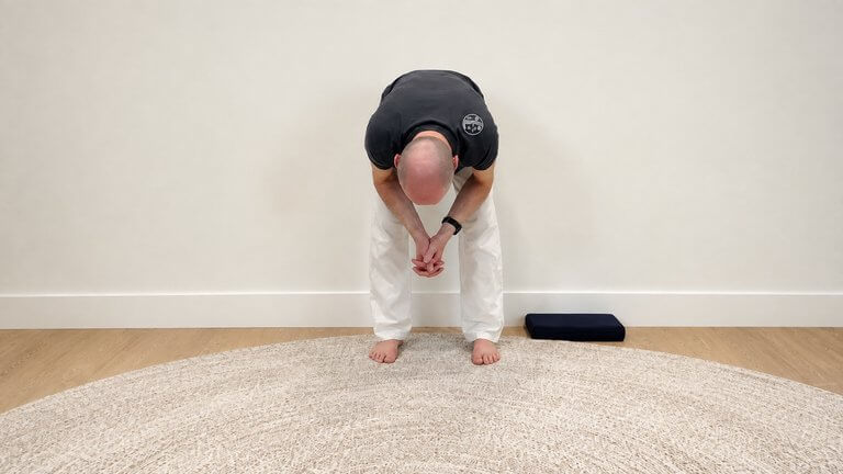Bernie Clark Demonstrating Dangling Yin Yoga Pose with elbow on the knees variation