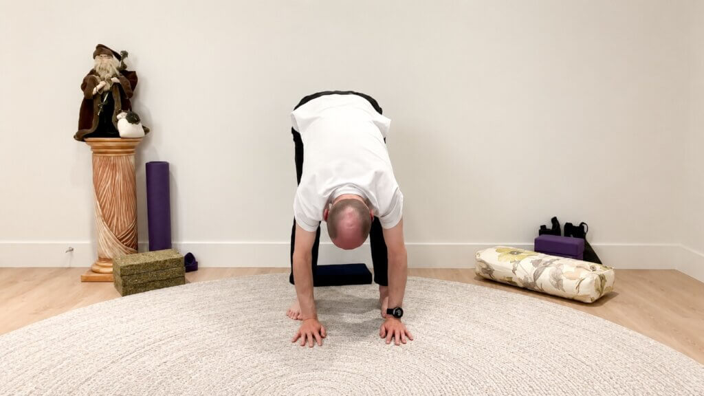Bernie Clark practicing Dangling Pose, a standing forward fold in Yin Yoga