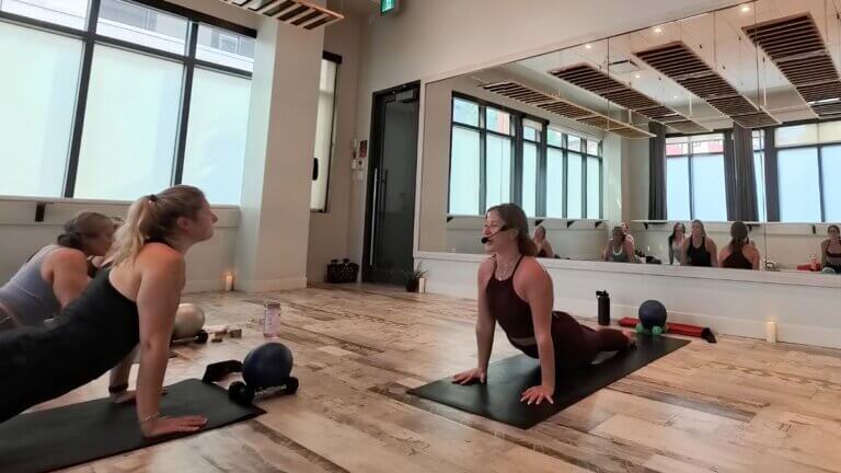 Lauren McBain leading students through a yoga-based movement during a Yoga Sculpt class.