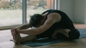 Kevin folding forward over his extended leg in Janu Sirsasana C.